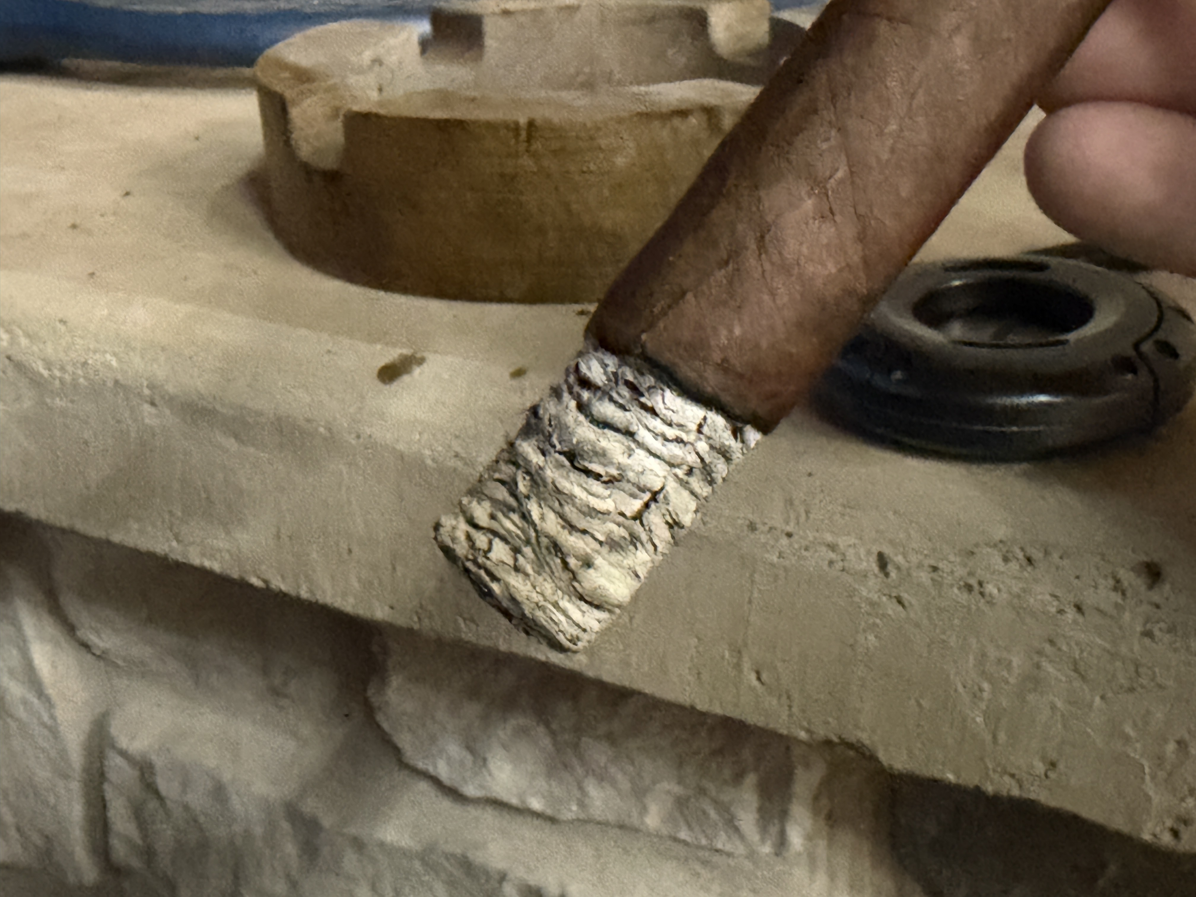 Lit New World Gobernador Toro with a tight light-gray ash stack building on the foot