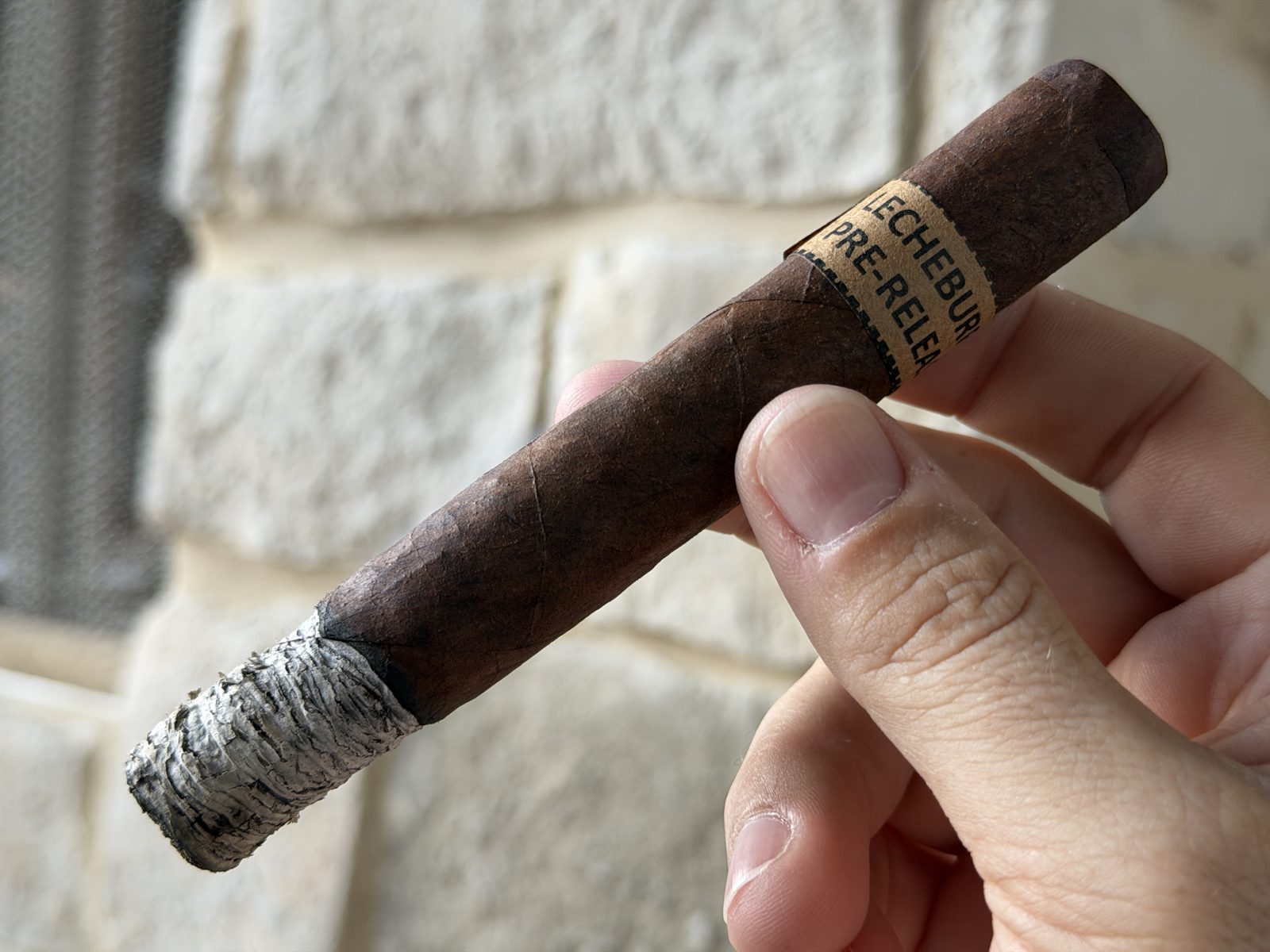 LecheBurra in the first third with a tight stacked white-gray ash and an even burn line
