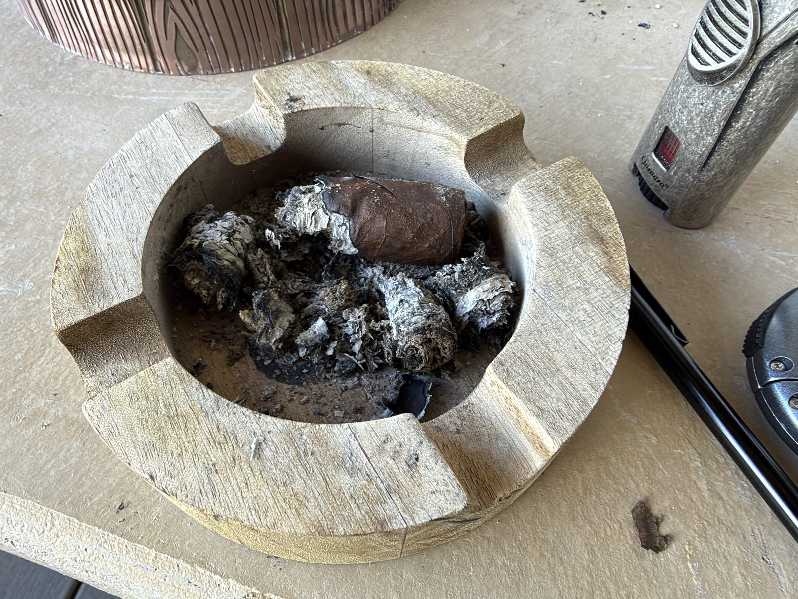 Wooden ashtray holding the remains of the Dunbarton Sin Compromiso Seleccion No. 7 and a pile of crumbled gray ash chunks