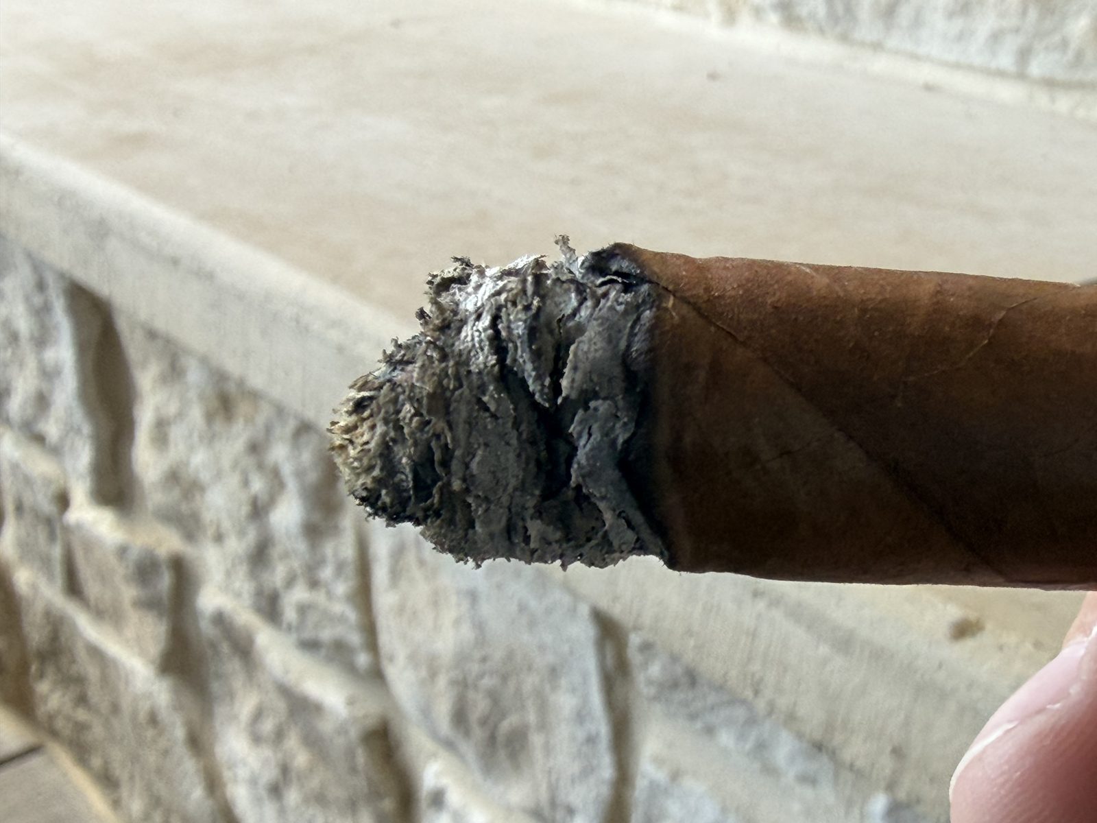 Foot of the Fuente Fuente Opus X Perfecxion X at the start of the final third, band removed, with a ragged partial ash and a wavy burn line