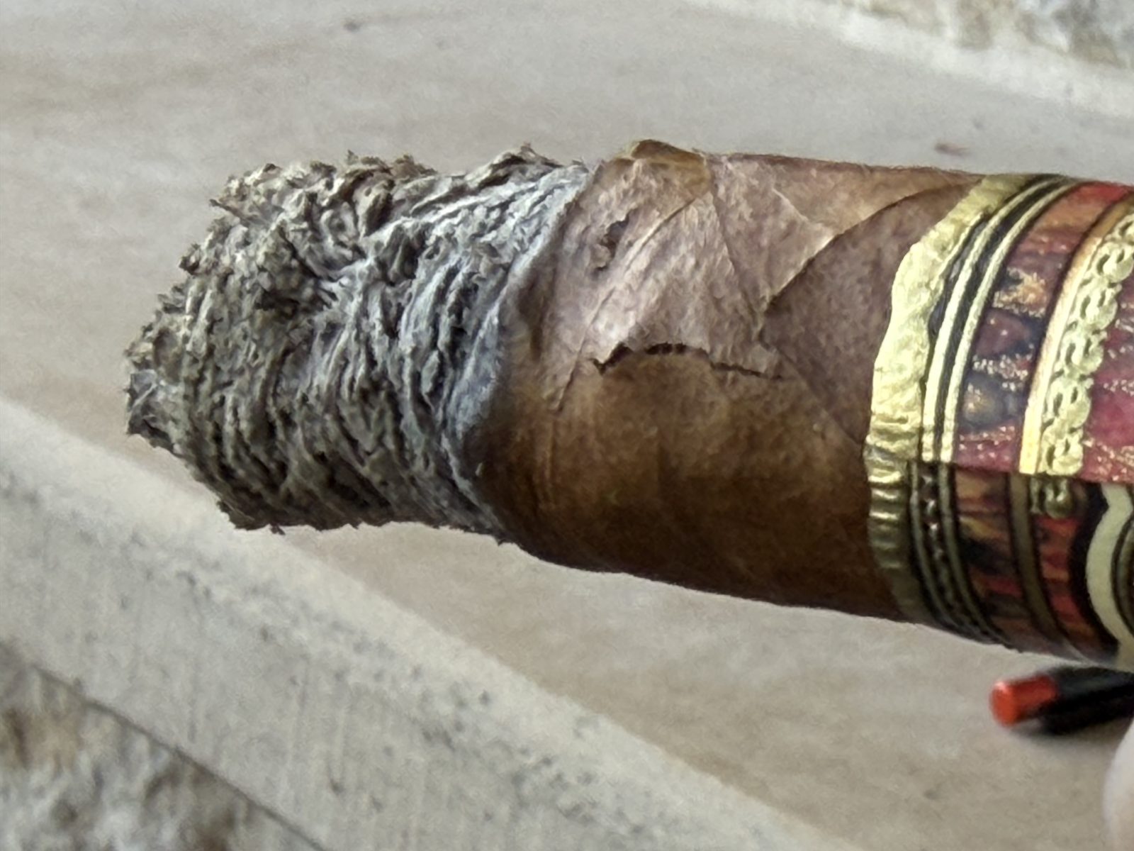 Crack in the wrapper of the Fuente Fuente Opus X Perfecxion X just above the burn line, next to the flaky ash and the gold band edge