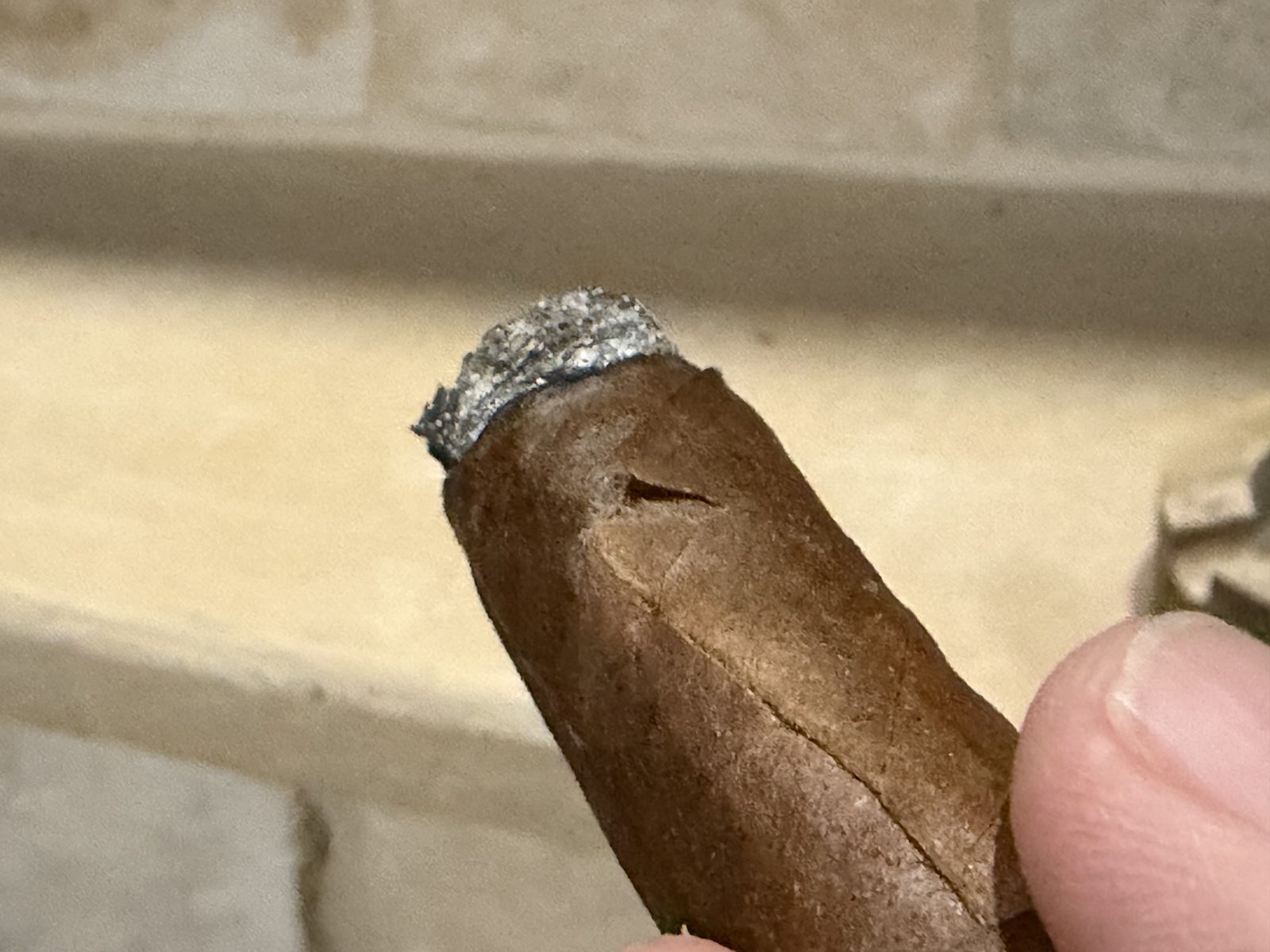 Close up of the La Aroma de Cuba Noblesse Viceroy with the bands off, showing a small crack in the San Andrés wrapper a short way below the burn line