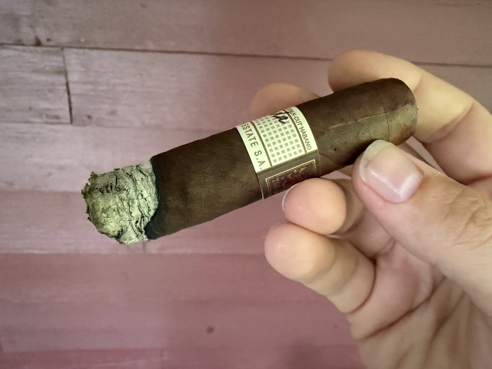 Close-up of the Liga Privada T52 foot band reading Stalk Cut Habano and Drew Estate S.A., cigar burned down into the second third
