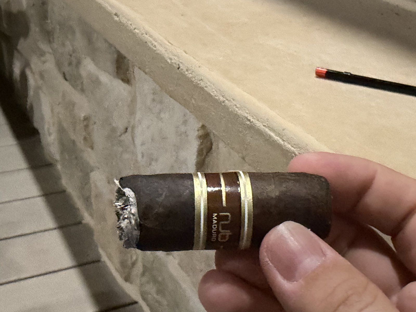 Nub Maduro 460 held in hand after the ash was knocked off, roughly half the cigar left