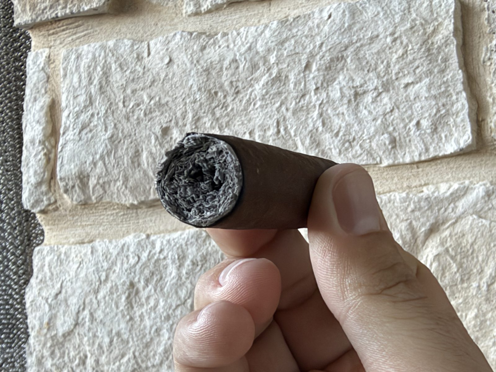 Close-up of the foot of the Oliva Serie V Maduro Toro at the start of the final third with ash knocked off, showing a hollow tunnel down the center of the cigar, no bands left on