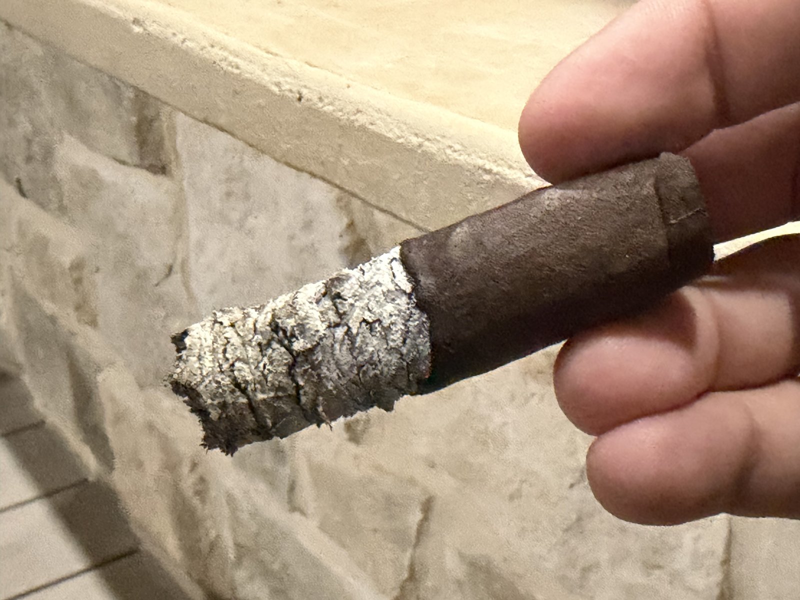 Padrón Family Reserve No. 45 Maduro nub in the final third with the bands off and a thick stacked ash still holding